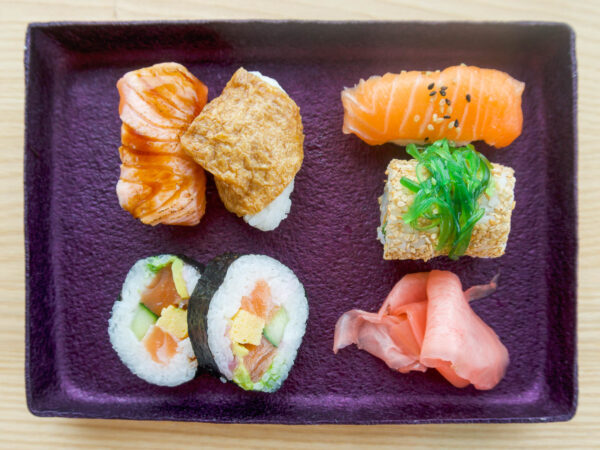 Ett lila rektangulärt fat med sushi.